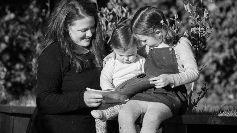 Woman and children look at book